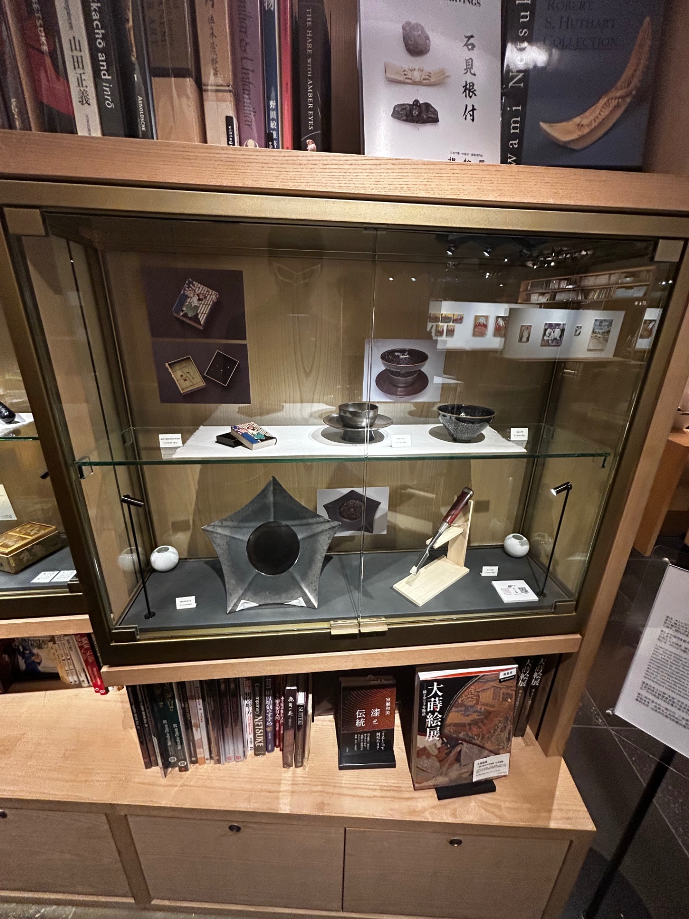 Display case of Japanese lacquerware and netsuke books