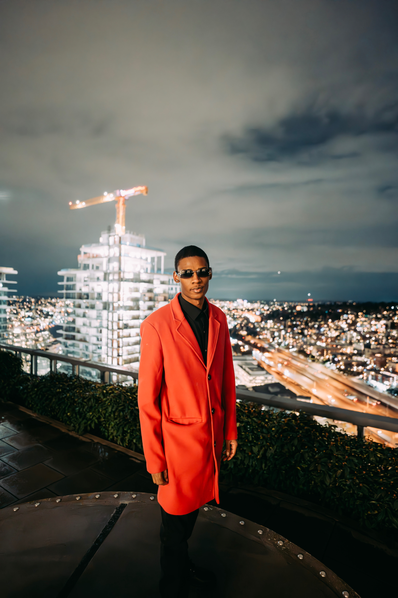 Red overcoat, rooftop skyline